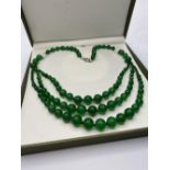 A graduating green jade necklace in a presentation box.