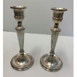 A pair of silver tapered candle sticks, both 25cms tall and the weight is 854g.