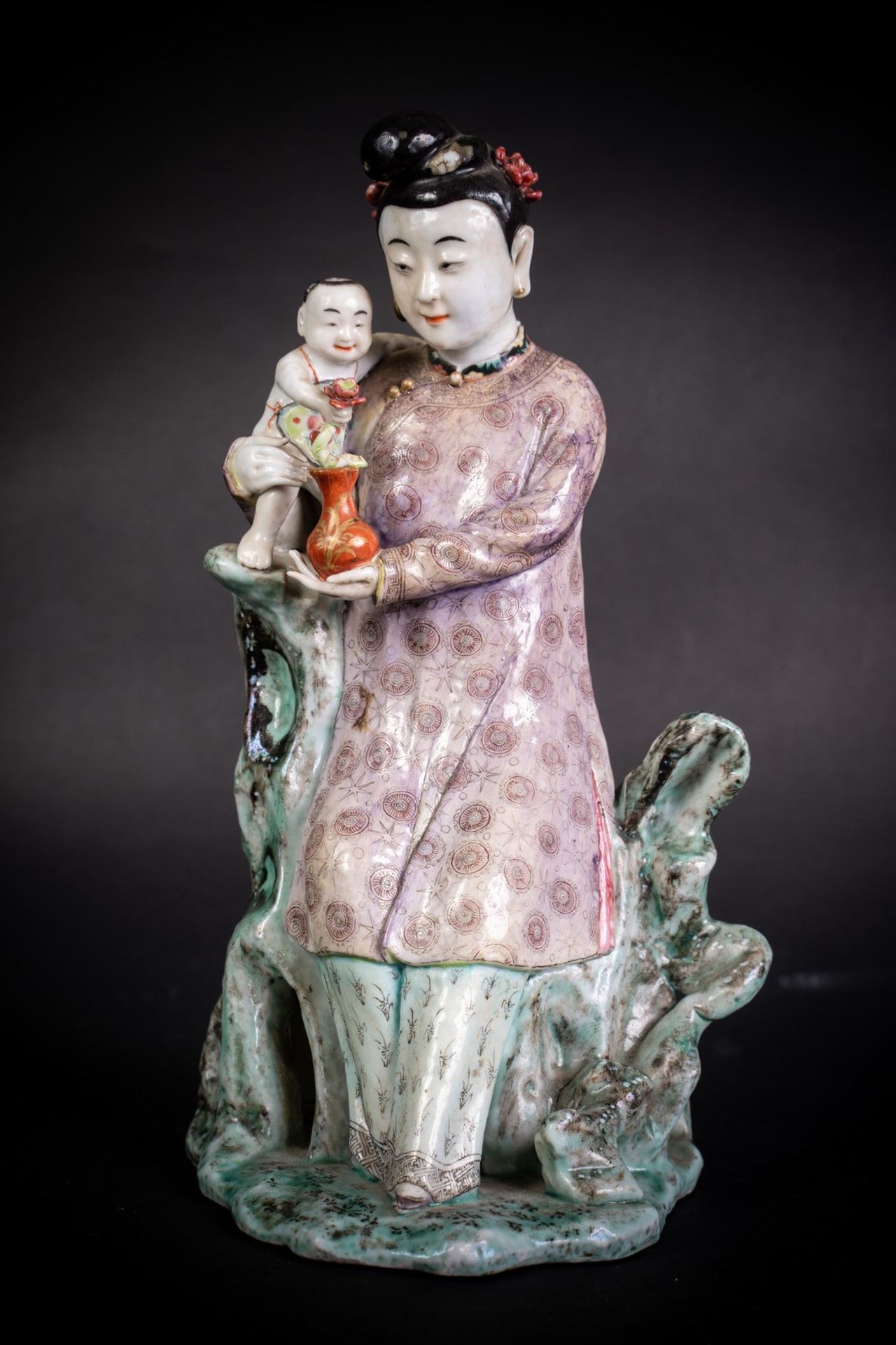 Arte Cinese An enamelled porcelain figure of a lady holding a child China, 19th century .