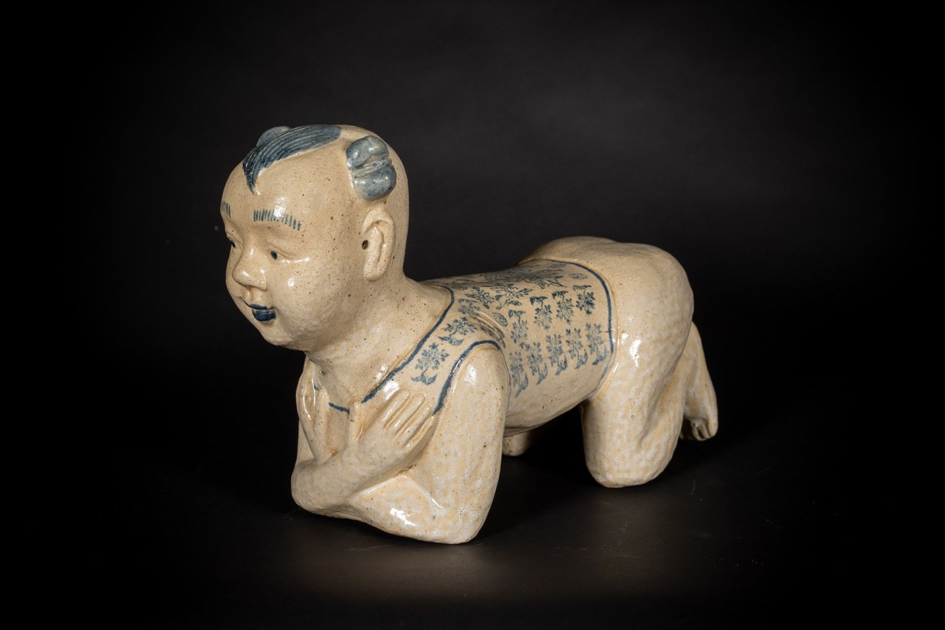 Arte Cinese A large cizhou headrest moulded in the shape of a crouched childChina, Qing dynasty, 19