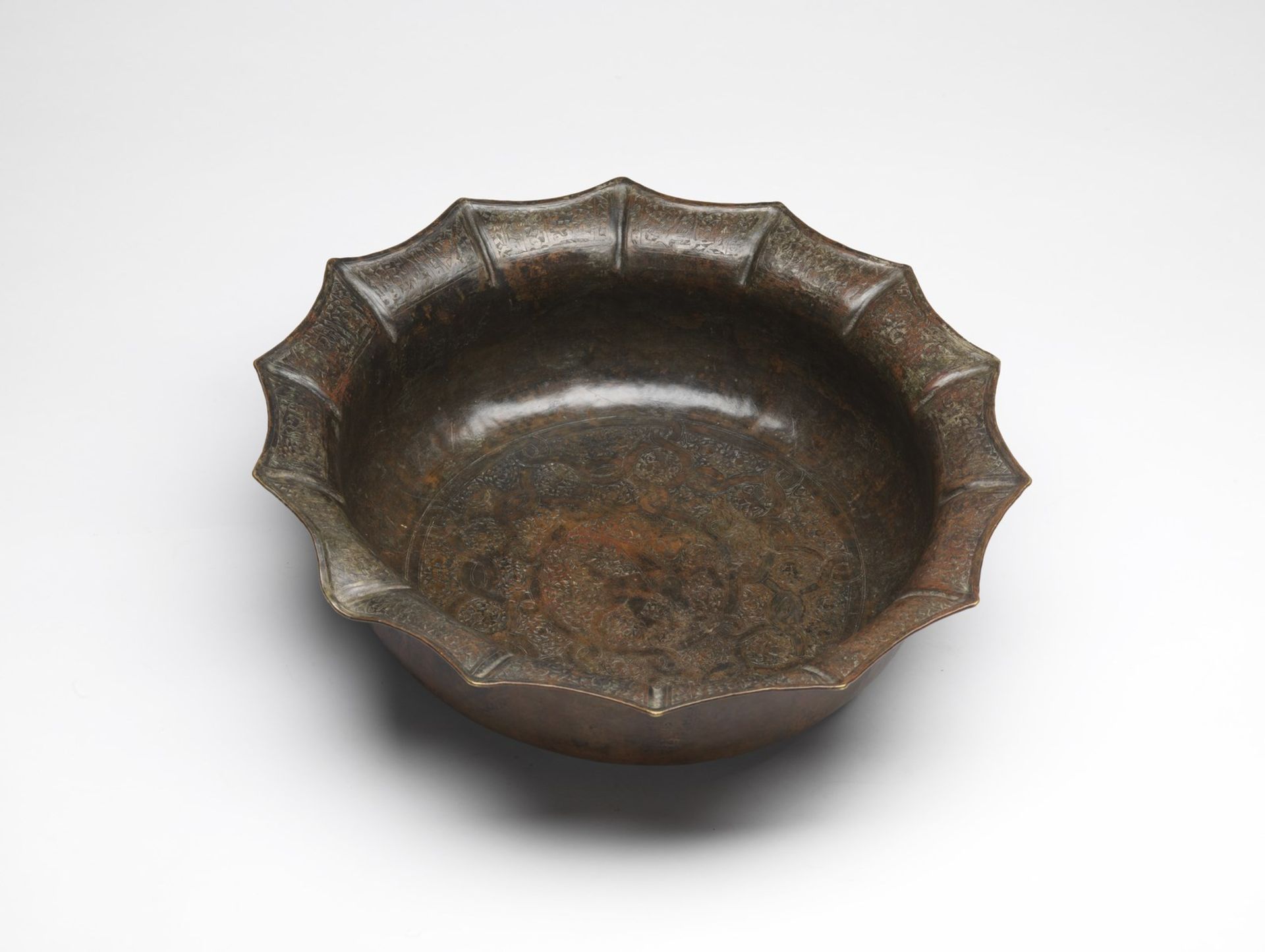 Arte Islamica A fine large bronze stellar basin engraved with sphinx over latticed background Khora