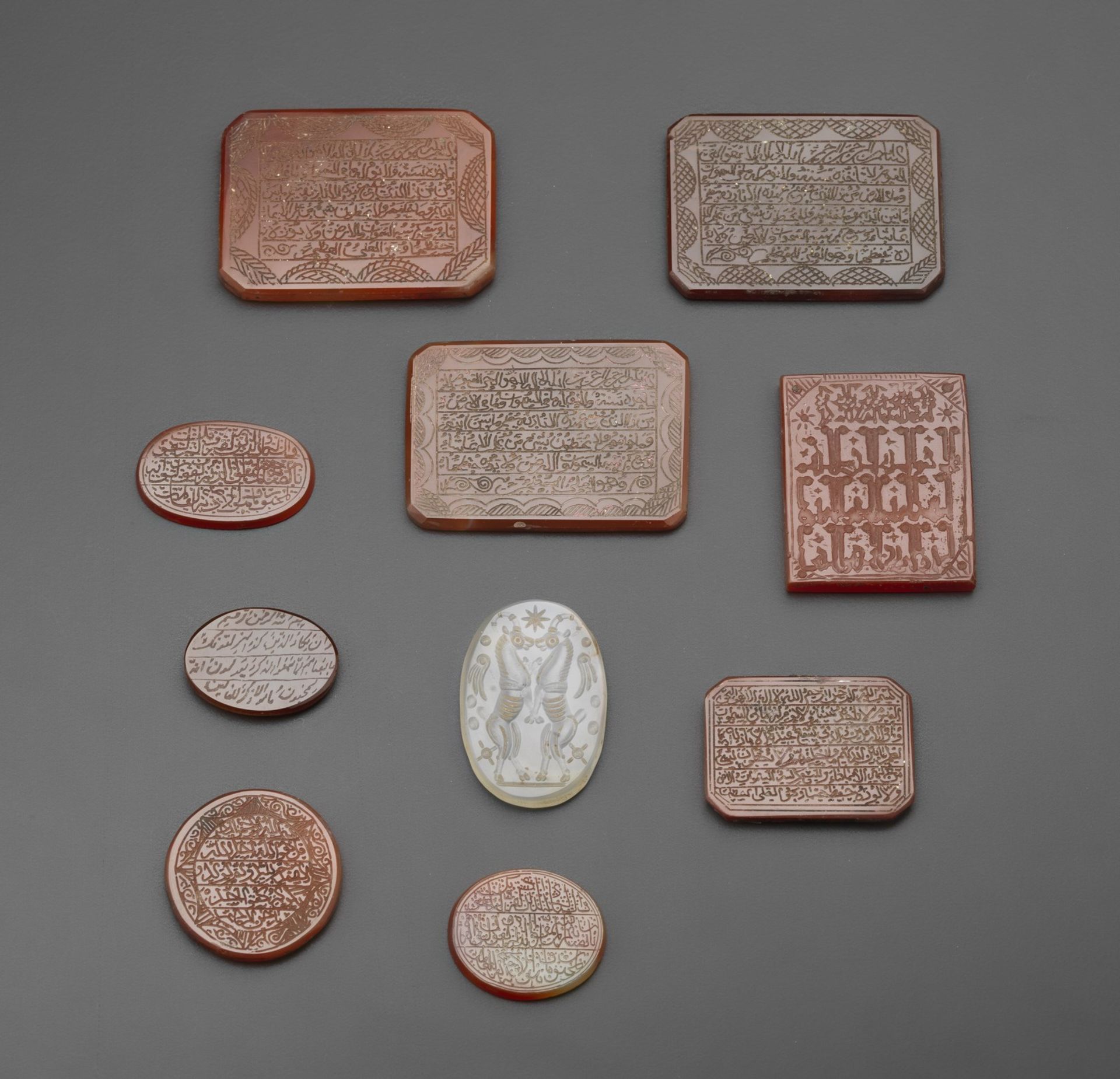 Arte Islamica A group of nine carnelian seals and one rock crystal plaque engraved with animals Per