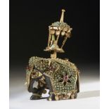 Arte Indiana An ebony elephant shaped chess piece partially coated with metal and garnets India, 19