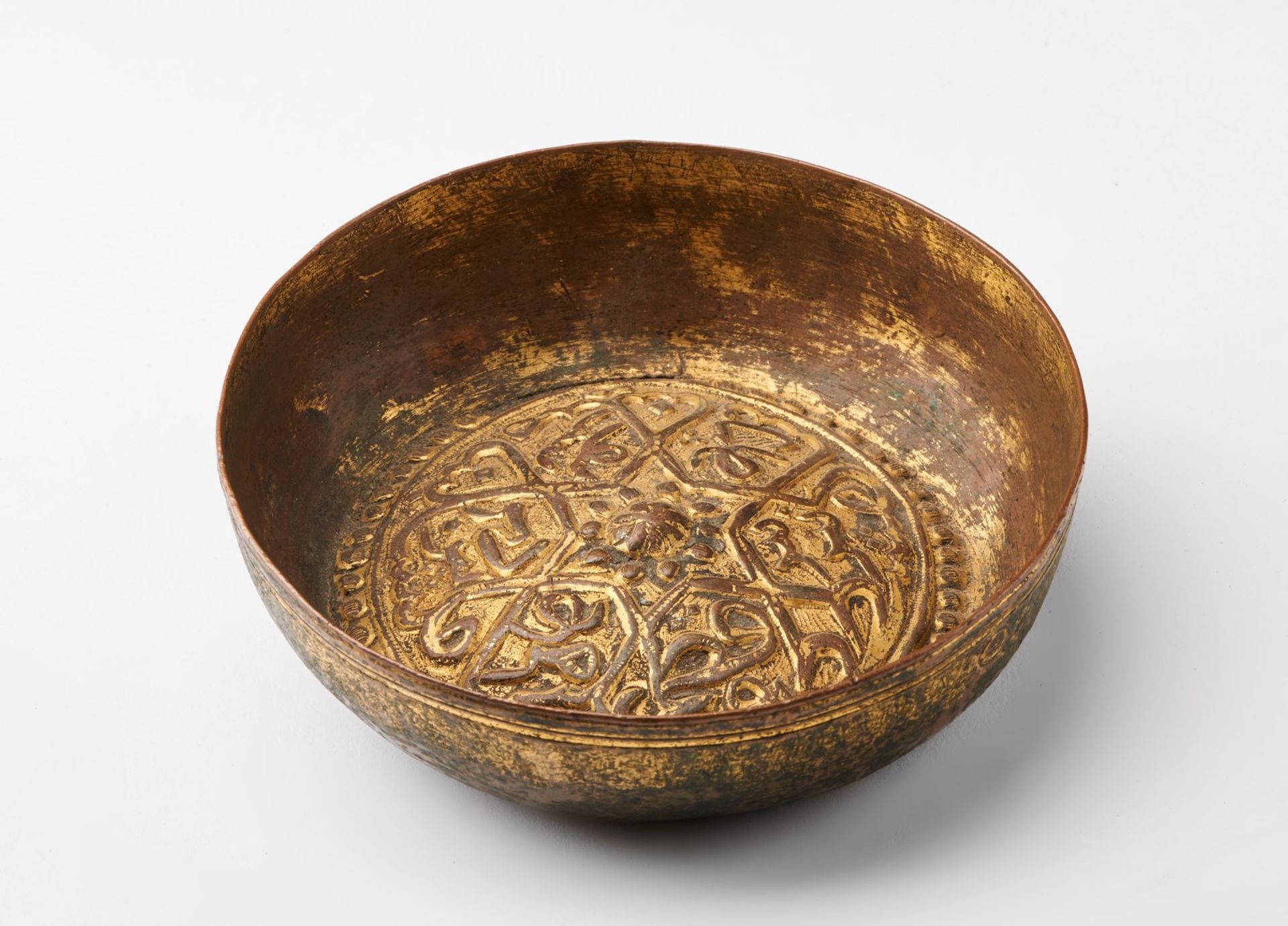 Arte Islamica A gilded copper (tombak) hammam bowl embossed with a star shaped lattice patternOttom