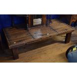 A low table, the top constructed from a 19th century Spanish pine door with studwork decoration, 167