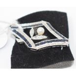 An 18ct white gold, sapphire and diamond brooch, of shaped lozenge form, centre with a pearl,