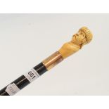 A walking cane, the carved ivory handle in the form of a man wearing a helmet, possibly a
