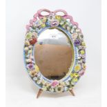 A 19th century Meissen style porcelain strut mirror, with a ribbon tie and encrusted flowers and