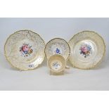 A 19th century porcelain part tea service, decorated flowers within a gilt seaweed border,