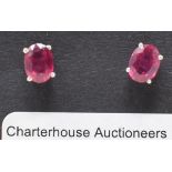 A pair of silver and treated ruby stud earrings, boxed