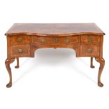 An 18th century style walnut serpentine front lowboy, crossbanded and with feather banding, having