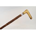 A military themed walking cane, having an L shaped antler handle, the shaft with carved decoration