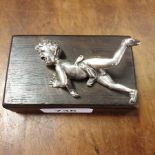 A silver coloured metal figure, of a fallen skater, on a hardwood base, 9.5 cm wide