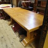 A 17th century style oak refectory table, on stout end supports joined by a stretcher, and with