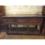 An 18th century style oak dresser base, having three frieze drawers, on baluster turned supports