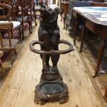 A late 19th/early 20th century Black Forest carved bear stickstand, with glass eyes and open