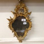 A mirror, in a carved giltwood frame, 40 cm high Report by RB Some damage, loss and repairs