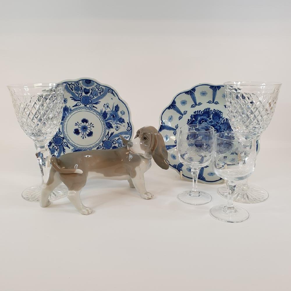 A Lladro porcelain basset hound, 20 cm wide, two Delft plates and assorted glassware (box)