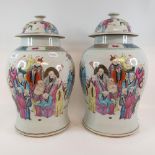 A pair of Chinese famille rose vases and covers, of baluster form, decorated figures, 41 cm high (2)