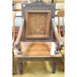 An oak wainscot armchair, the panel back inlaid with a vase of flowers, on turned front legs