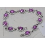 An 18ct white gold, pink sapphire and diamond oval line bracelet, pink sapphires approx. 10.15ct,