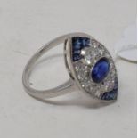 A platinum marquise shaped ring, set a central oval sapphire within a surround of diamonds, and with