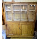 A small pine cupboard, having a glazed section above a pair of panel doors, 98 cm wide