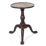 A George III mahogany kettle stand, the circular dished top on a baluster turned column and tripod