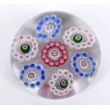 A Baccarat glass paperweight, with seven inset circles of coloured glass canes, 7.3 cm diameter