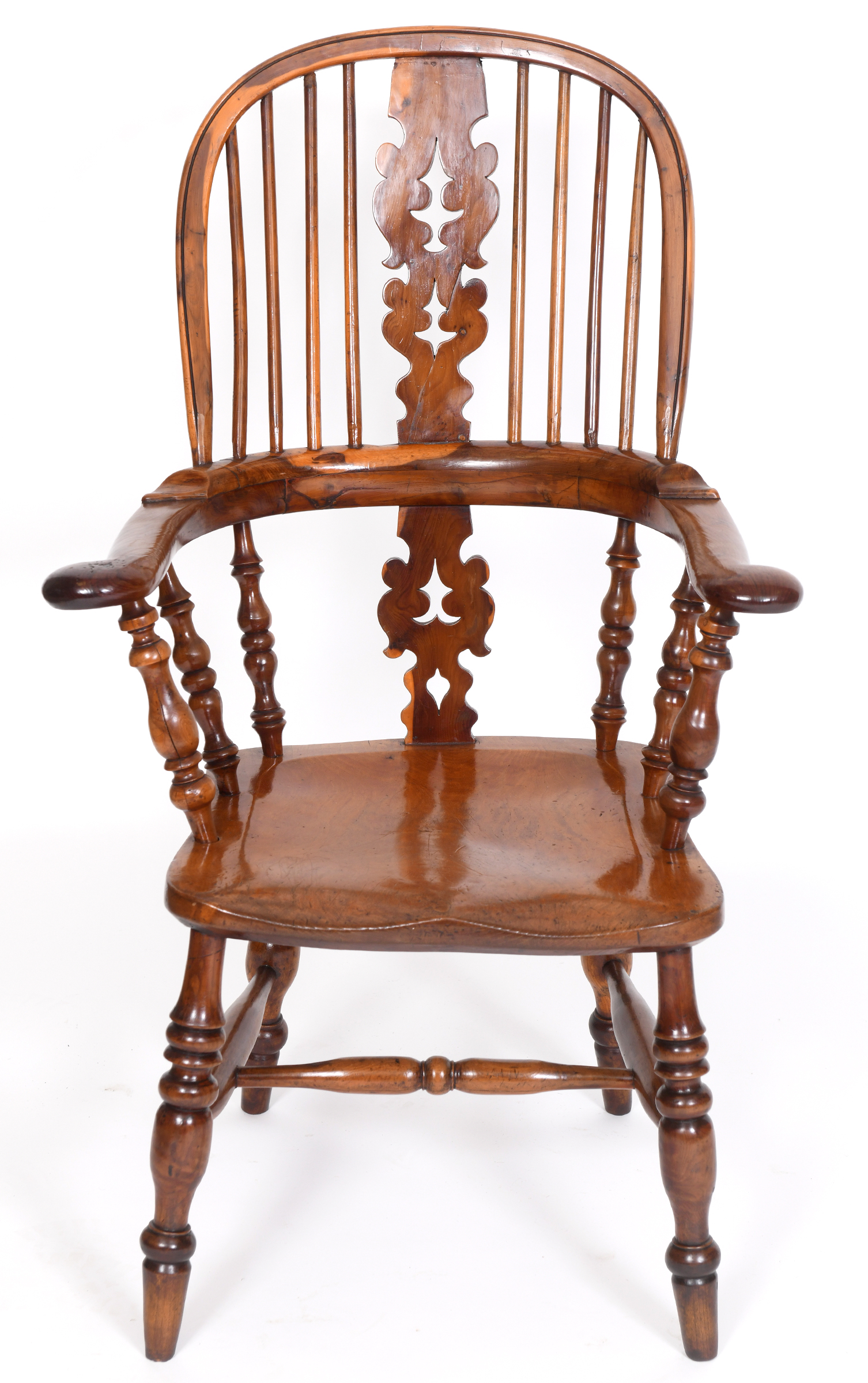 A yew and elm Windsor type kitchen armchair, the splat pierced Christmas trees, on turned legs