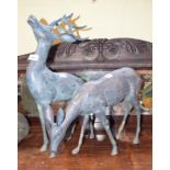 A pair of 20th century cast metal figures, of a stag and doe, each modelled in a standing pose,