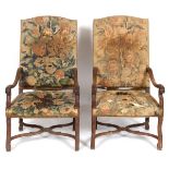 A pair of 18th century Continental walnut armchairs, carved bell flowers, upholstered in