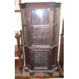 An oak display cabinet, having a glazed door above a panel door, incorporating 17th century