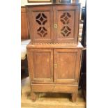 A mahogany cabinet, in two parts, having a pair of pierced panel doors above a pair of panel