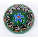 A Paul Ysart glass paperweight, the green ground decorated with central flowerhead, flanked by multi