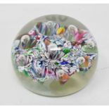 A Paul Ysart glass paperweight, the scrambled multi coloured cane ground with inset bubbles, applied