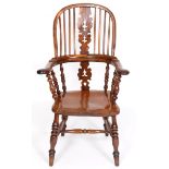 A yew and elm Windsor type kitchen armchair, the splat pierced Christmas trees, on turned legs