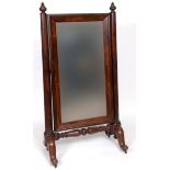 A large early Victorian mahogany cheval mirror, on tapering cylindrical columns joined by a turned