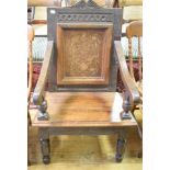 An oak wainscot armchair, the panel back inlaid with a vase of flowers, on turned front legs