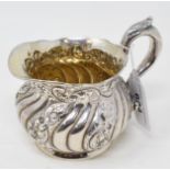 A Sterling silver milk jug, initialled to the underside, with embossed decoration, approx. 5.3 ozt