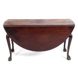 An 18th century mahogany oval drop leaf table, on cabriole legs carved scrolls, and with claw and