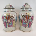 A pair of Chinese famille rose vases and covers, of baluster form, decorated figures, 41 cm high (2)