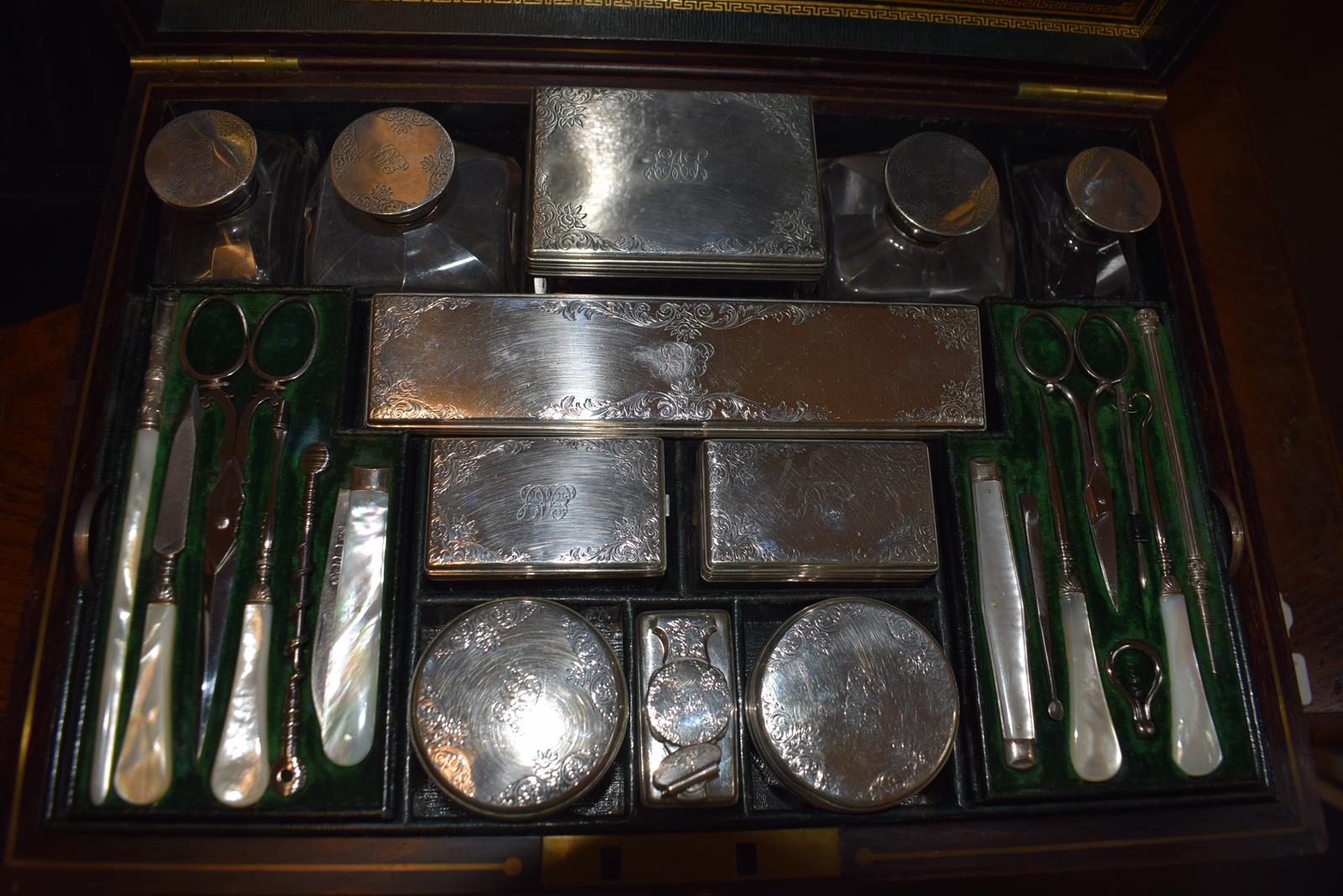 A Victorian rosewood travelling dressing case, the silver mounts initialled and ingraved scrolling