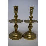 A pair of brass candlesticks, with wide drip pans, drilled, 25.5 cm high (2)