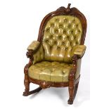 A 19th century oak rocking armchair, the crest rail carved an eagle, the arms grotesque masks and