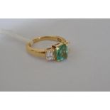 An 18ct gold emerald and diamond three stone ring