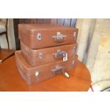 A graduated set of three leather suitcases, the largest 70 cm, a modern beech kitchen table, 130