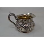 A Sterling silver milk jug, initialled to the underside, with embossed decoration, approx. 5.3 ozt