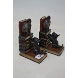 A pair of painted bronze bookends, in the form of a Scottie dog, a cat and books, 14 cm high Modern