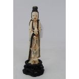 An early 20th century Chinese carved, stained and painted ivory figure, of a lady holding beads